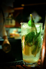 Glass of mojito with bartender background