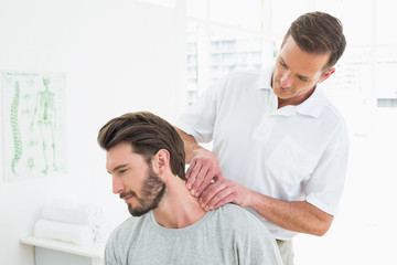 Male therapist massaging a young mans neck