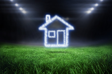 Cloud in shape of house against football pitch with bright lights