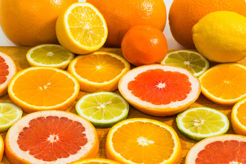 Citrus fruit background with sliced f oranges lemons lime tangerines and grapefruit