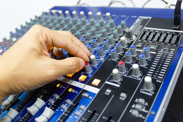 hands of Men are controlling the console of a large hi-fi system. Sound equipment. Control panel of a digital studio close-up mixer.
