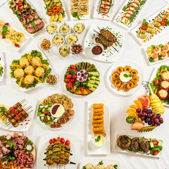 Different snacks for eating on holiday in white plates on white background. Kitchen, menu, food concept . delicious dish