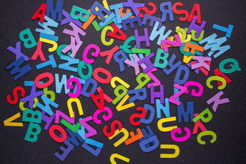 Colorful wooden alphabet. Top view on black stone.