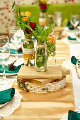 Festive table setting in the restaurant with flowers. Wedding decor.