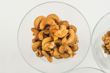 roasted peanuts isolated in glass bowl, on white background