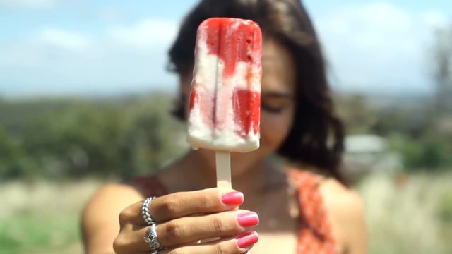 Young Woman holds melting Ice Cream to camera