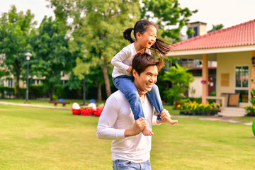 Obraz premium Parents and daughters go for a walk in the park.