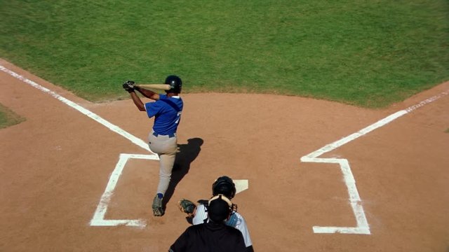 Elevated slow-motion rear view of batter hitting a line drive toward third base