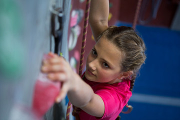 Determined teenage girl practicing rock climbing