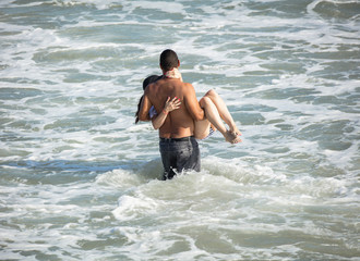 Fototapeta premium unknown romantic couple prepares to take the plunge at their beach side wedding