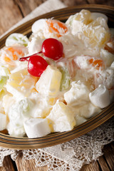 fruit salad Ambrosia from pineapple, tangerine, grapes and marshmelow close-up. vertical
