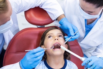 Dentists examining young patient in dental clinic