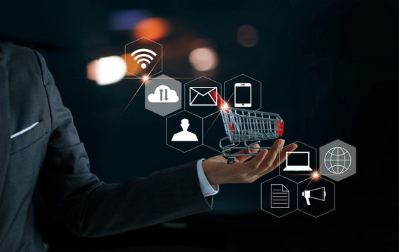 Businessman with shopping cart in hand and icons customer network connection. Digital marketing and shopping online. Business and payment concept
