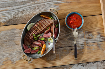 Grilled beef meat served pan wooden table sauce top view