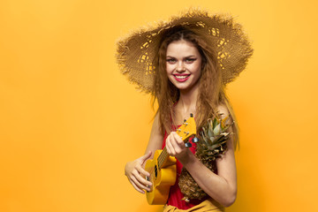 happy woman with ukulele and pineapple in hands