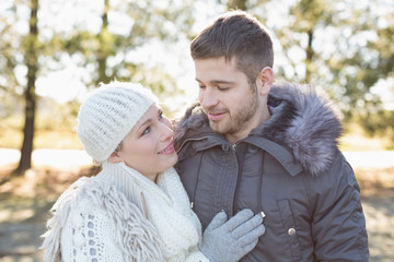 Fototapeta premium Smiling couple in winter clothing in the woods