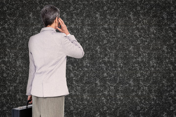 Businesswoman on the phone against black background