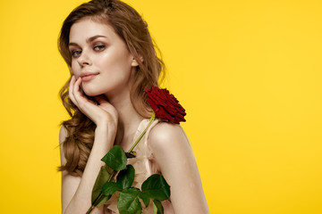 beautiful woman with a rose on a yellow background