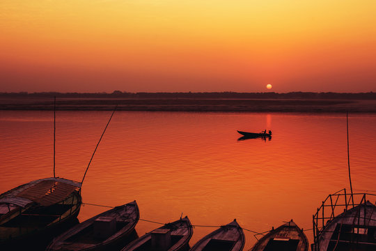 Orange Sunrise and Old style boats on Gang river, Varanasi