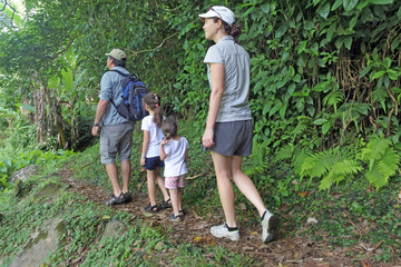 Family hiking the Cross Island Track in the rain forest of a tropical pacific island