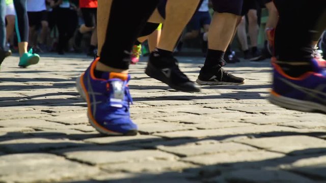 Marathon runners. closeup legs of runners on cobbles city street. Challenge, health, wellness, lifestyle concept