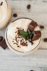 Iced Mocha Coffee with Whip Cream, Summer Drinking times. Coffee Beans. rustic textured Wooden Background. Mint Leaves