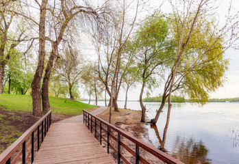 Naklejka na ściany i meble Footbridge, close to the Dnieper river, in the Natalka park in Kiev, Ukraine, during a cloudy spring morning