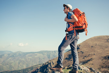 Hiker with backpack standing on a viewpoint