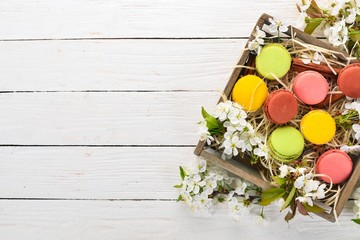 Macaroons colorful. Cake In a wooden box. Top view On a wooden background, Copy space.