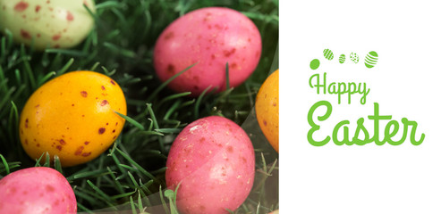 Happy Easter greeting against many little easter eggs in the grass