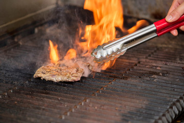 Prime steak being grilling on an open flame