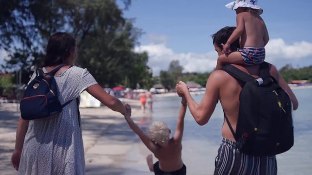 Mother and father hold his son by the arms, and try to lift and shake, daughter, sitting on her shoulders and looking. low motion, 1920x1080, full hd