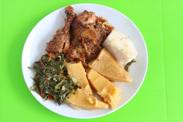 Homemade Creole chicken with breadfruit served in the Caribbean on bright green background