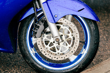 Obraz premium Motorcycle wheel with disk brakes system and metal spokes. Closeup detailed photo of motorbike forks and tire. Different parts of two-wheeled vehicle. Transportation. Modern driving technologies.