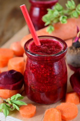 Red smoothie made of carrot and beet in a glass jar