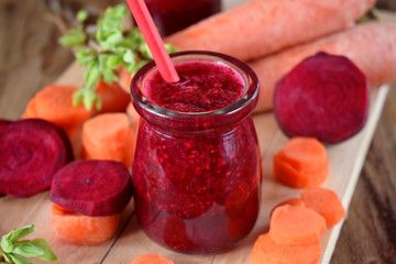 Red smoothie made of carrot and beet in a glass jar