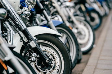 Motorcycle wheel with disk brakes system and metal spokes. Closeup detailed photo of motorbike forks and tire. Different parts of two-wheeled vehicle.  Transportation. Modern driving technologies.