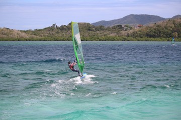 Girl windsurfing in the turquoise Caribbean water near Trois Ilets, Martinique