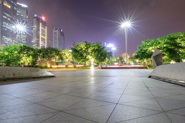 empty square floor and modern city landscape at night