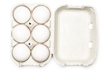 Six white chicken eggs in a paper grey crate isolated on white background top view.