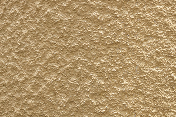 Very coarse texture of a single-colored yellow wall with sharp shadows