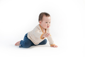 The baby is playing on the floor, the white background