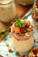 Yogurt in a glass jar topped with granola and mint. Breakfast idea