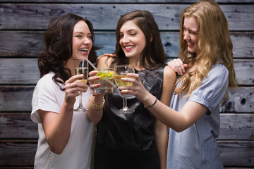 Friends with drinks against grey wooden planks