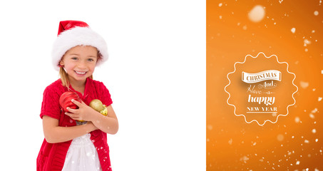 Cute little girl wearing santa hat holding baubles against orange vignette