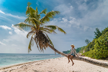 young woman at the beach during vacation at the tropical islands of the Seychelles with huge...