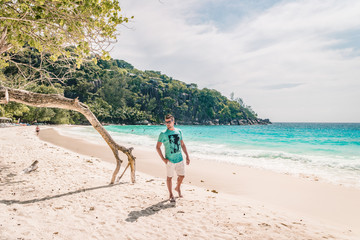 young man at the beach during vacation at the tropical islands of the Seychelles