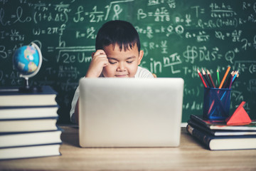 kid  use computer laptop  in the classroom.