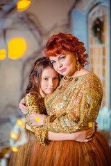Beautiful red-haired mother hugging daughter