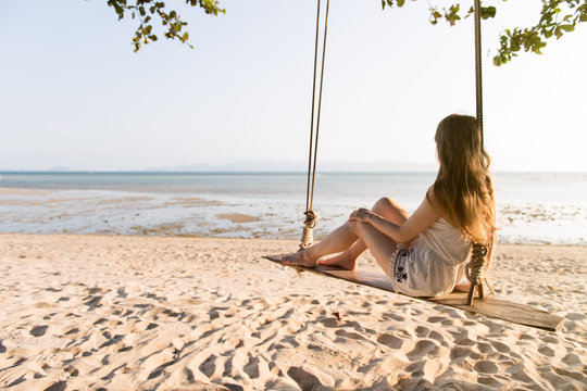Woman on swings on beach